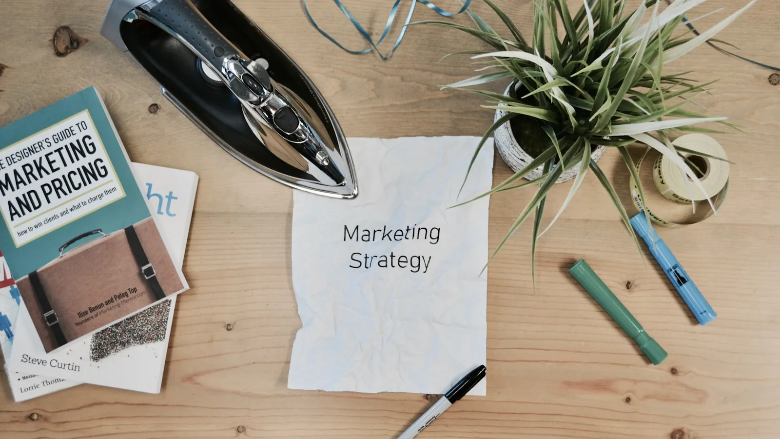 Nota con las palabras Marketing Strategy sobre un escritorio con material de marketing