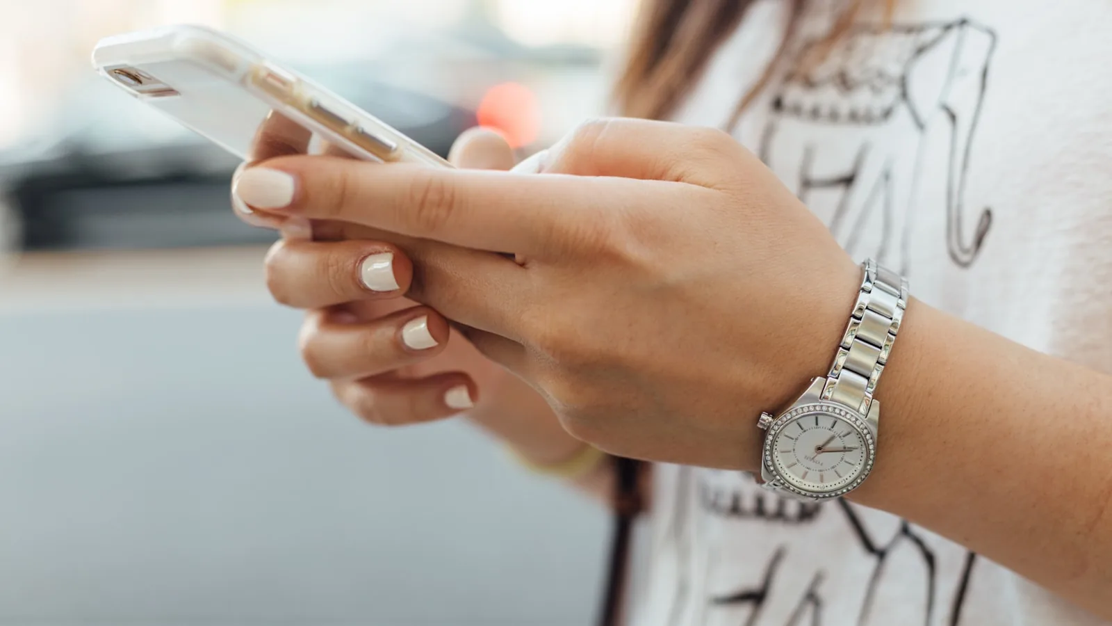 Manos de una persona sosteniendo y usando un teléfono móvil
